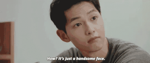 a man is looking at the camera and says `` how ? it 's just a handsome face . ''