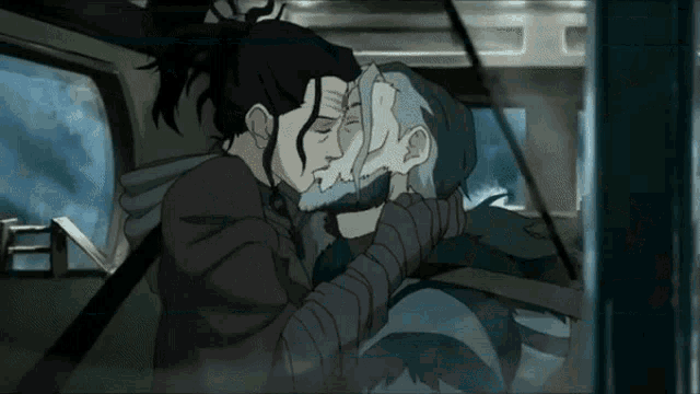 a man with a beard is kissing another man in a car