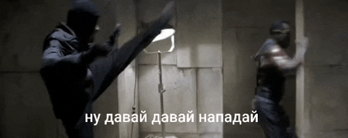 a man in a mask kicking another man in a dark room with a caption in russian