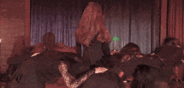 a group of women are dancing on a stage with a green lamp in the background