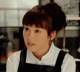 a close up of a woman wearing a white shirt and an apron .
