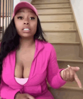 a woman in a pink jacket and hat is sitting on stairs .