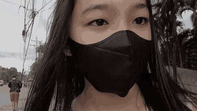 a young girl wearing a black face mask