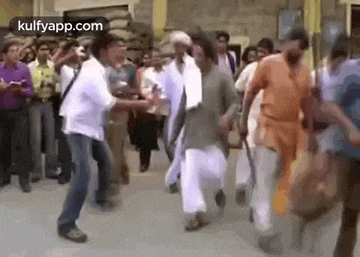 a group of people are dancing on a street in a crowd .