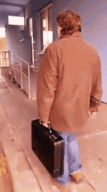 a man in a brown coat carrying a black briefcase
