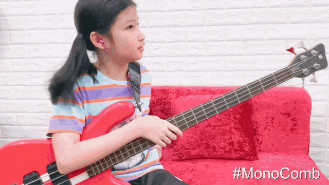 a girl is playing a red guitar on a red couch with #monocomb written on the bottom