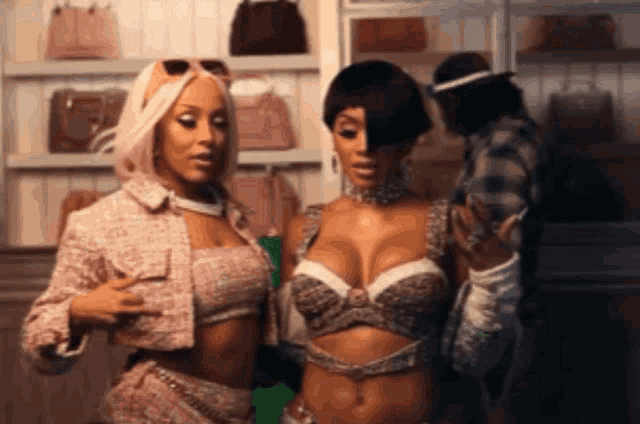 a couple of women standing next to each other in front of a closet full of handbags .