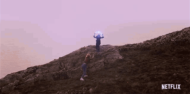 a netflix ad shows a person standing on a rocky hill