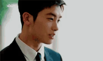 a close up of a man in a suit and tie looking at the camera .