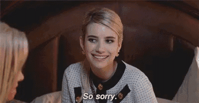 a woman is sitting on a bed with her eyes closed and saying `` so sorry '' to another woman .