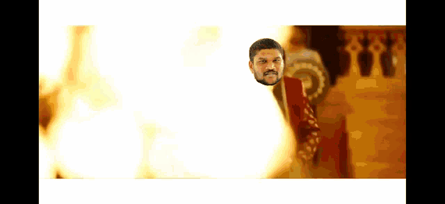 a man is standing in front of a fire with his head visible