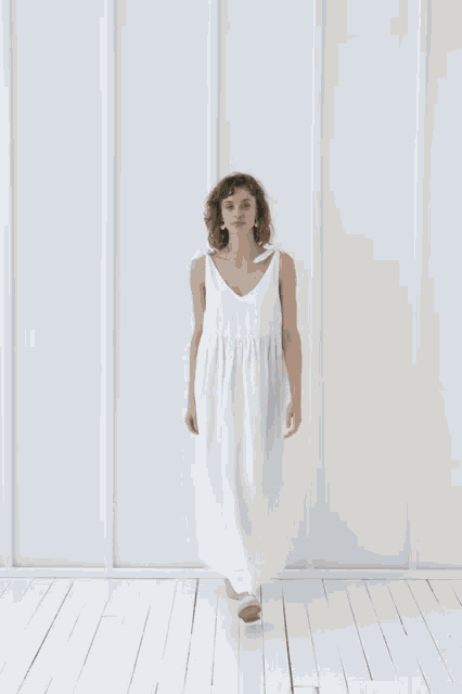 a woman wearing a white dress with a v-neck