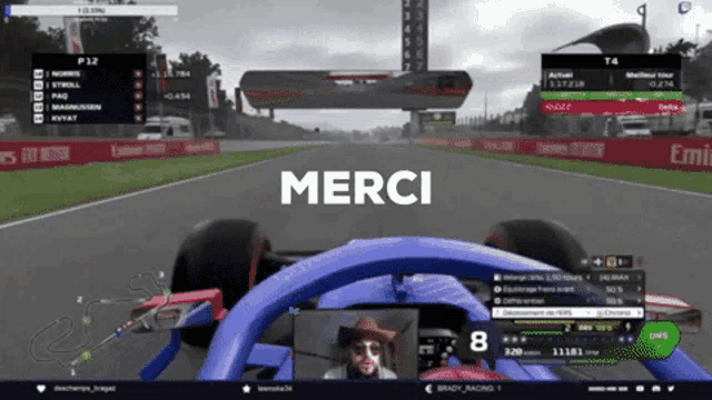 a blue race car is driving down a track and the word merci is on the screen