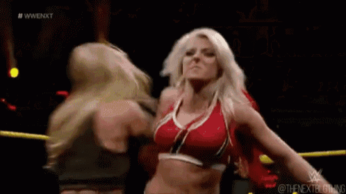 two women are wrestling in a ring and one of them is holding the other 's head .