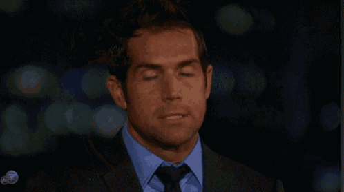 a man in a suit and tie is looking at the camera