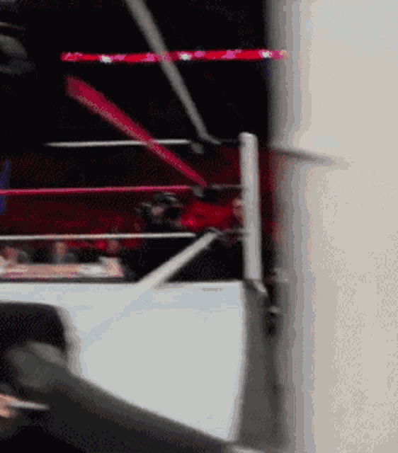 a blurry picture of a wrestling ring with a red light behind it