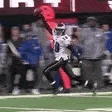 a football player is running on a field during a game with a crowd watching .
