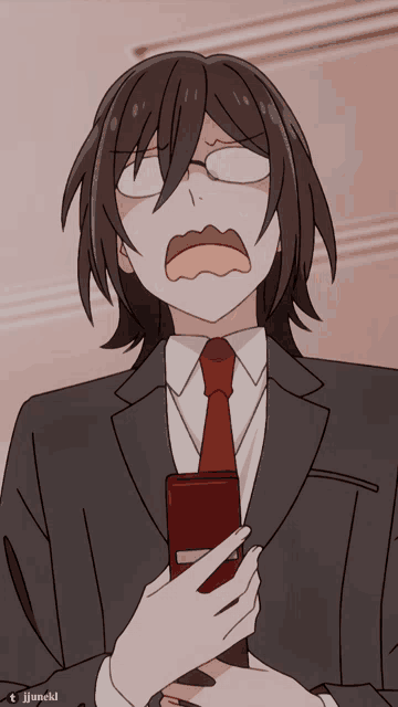 a man in a suit and tie is holding a cellphone