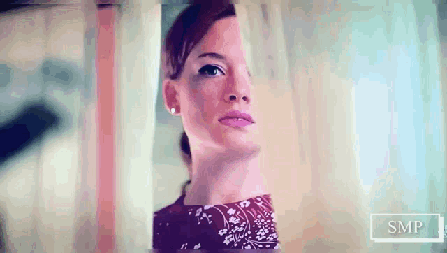a woman behind a curtain with the word smp on the bottom left