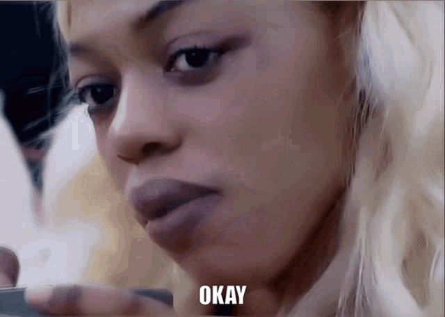 a close up of a woman 's face with the word okay below her