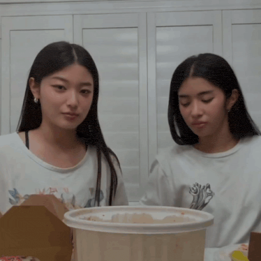 two women sitting next to each other with one wearing a shirt that says swag on it