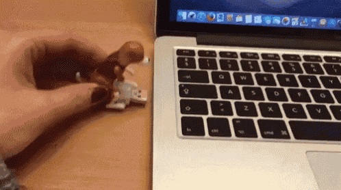 a person is holding a lego figure in front of a laptop