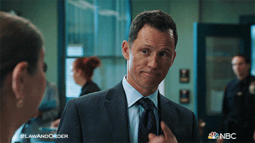 a man in a suit and tie is talking to a woman in a law and order advertisement