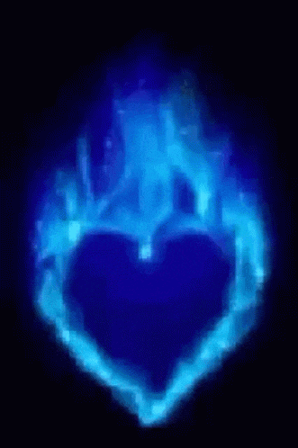 a blue heart shaped object is glowing in the dark