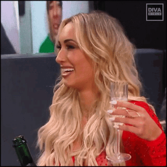 a woman is holding a glass of champagne and a bottle of champagne .
