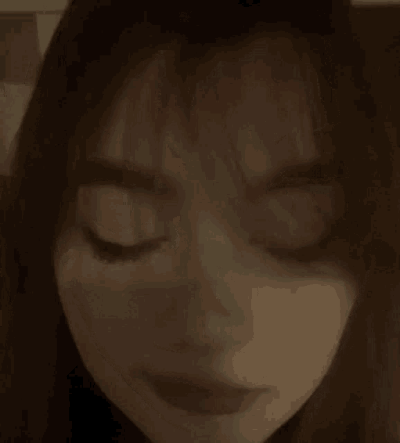 a close up of a woman 's face with her eyes closed and her mouth open .