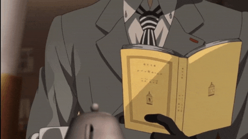 a man in a suit is reading a book with chinese writing on it
