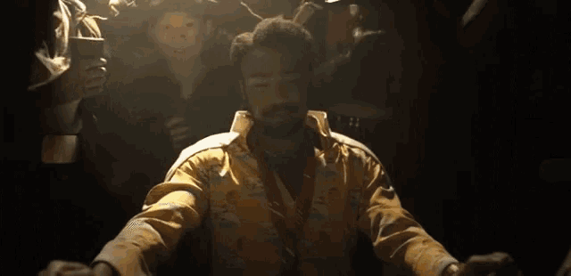 a man in a yellow shirt and tie is surrounded by other people