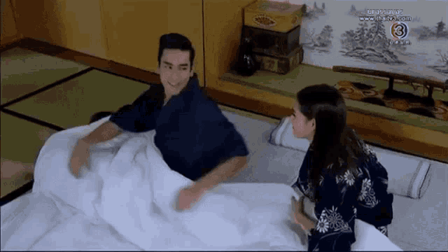a man and a woman are laying on a bed and the number 3 is on the bottom of the screen