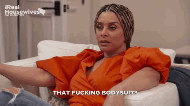 a woman sitting on a couch with the words that fucking bodysuit on her face