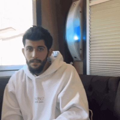 a man with a beard wears a white hoodie with the word obey on it