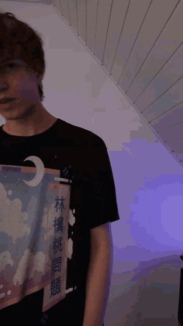 a young man wearing a black t-shirt with chinese writing on the front