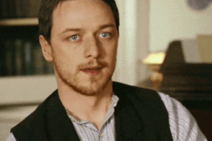 a man with a beard wearing a vest and striped shirt