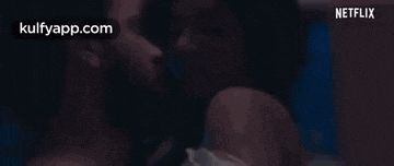 a man and a woman are kissing in a bed in a netflix movie .