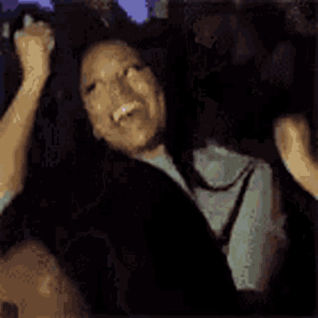 a woman is sitting in a car with her hand on her face .