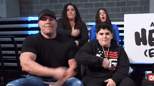 a group of people are sitting in front of a sign that says a he