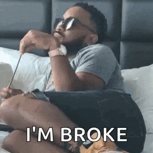 a man is sitting on a bed with his legs crossed and holding a pencil .