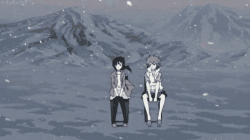 a boy and a girl are sitting in front of mountains in the snow
