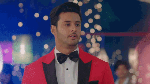 a man wearing a red tuxedo and bow tie