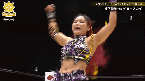 a female wrestler is smiling in front of a sign that says queen of queen on it