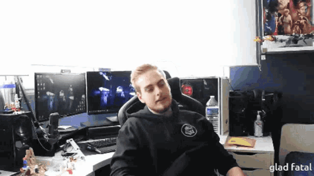 a man in a black hoodie sits in front of a computer monitor with the words glad fatal written below him
