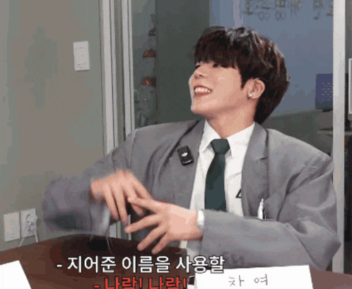 a man in a suit and tie is sitting at a table with a name tag that says ' a ' on it