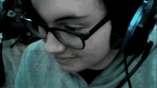 a woman wearing glasses and headphones looks down