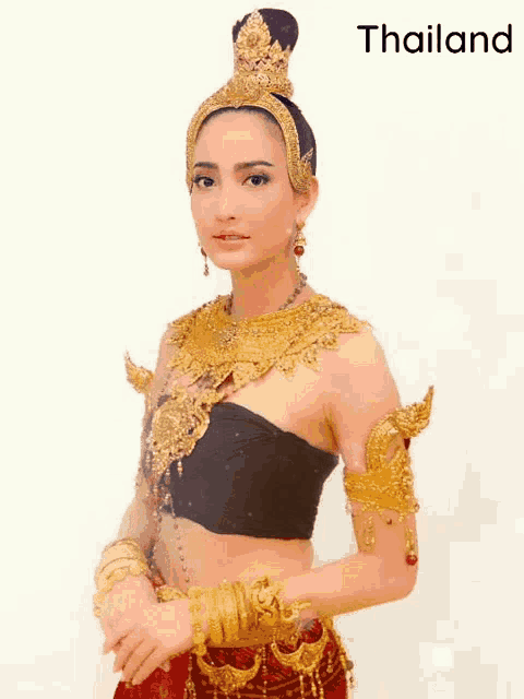 a woman in a black top and gold jewelry is standing in front of the word thailand