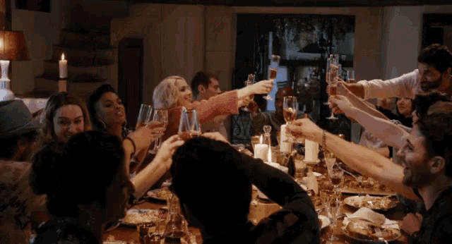 a group of people toasting with champagne glasses at a table