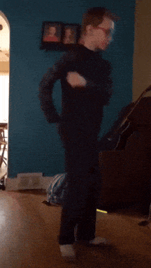 a boy with glasses is standing in a living room